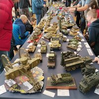 Visitors view a variety of detailed vehicle models at a model exhibition.