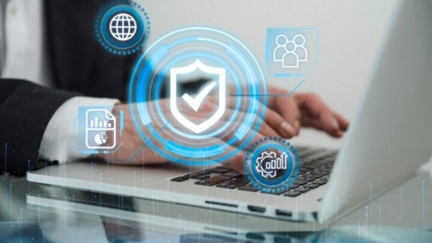 Arbeitskultur und Karriere in Steyr - Verhaltenskodex bei weba Werkzeugbau Nahaufnahme eines Laptops mit arbeitenden Händen darauf, über denen transparent verschiedene Sicherheitssymbole liegen.