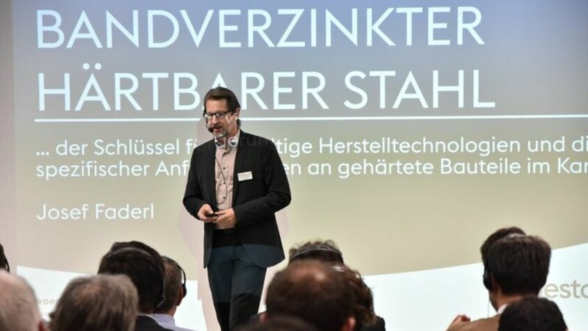 weba Werkzeugbau TechDays - Leichtbauanwendungen von bandverzinkten härterbaren Stählen Josef Faderl von voestalpine Stahl GmbH präsentiert auf der Bühne der weba Werkzeugbau TechDays die Möglichkeiten für Leichtbauanwendungen von bandverzinkten härterbaren Stählen