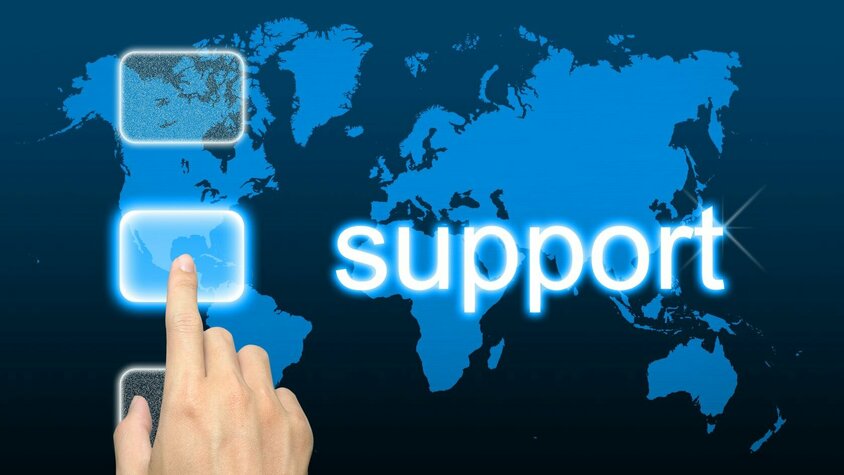 Mobiler Werkzeugbauservice Hand zeigt auf Weltkarte mit „Support“-Schriftzug – Symbolbild für internationalen Kundenservice
