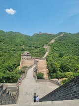 Perspective along the Great Wall stretching over green hills and valleys, with visitors walking along the path – one of Jan Wengryn’s memorable experiences in China.