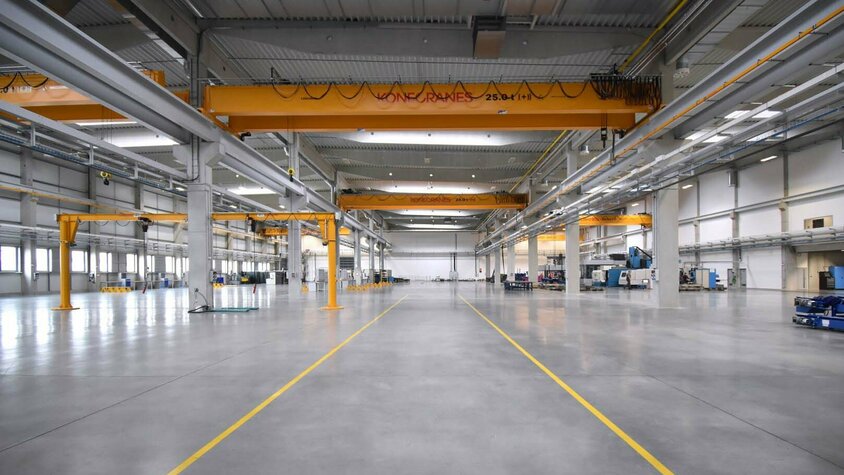 weba Olomouc - Werkzeugbau-Experte für Warmumformung Die Produktionshalle der weba in Olomouc kurz nach der Erweiterung; weitläufiger Produktionsbereich mit großen Kränen.