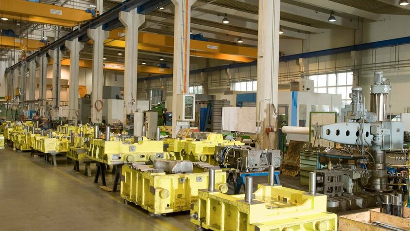weba Werkzeugbau - Prozessoptimierung in der Werkzeugherstellung Produktion der weba Werkzeugbau mit gelben Transferwerkzeugen im Fokus, umgeben von Maschinen und industrieller Ausstattung.