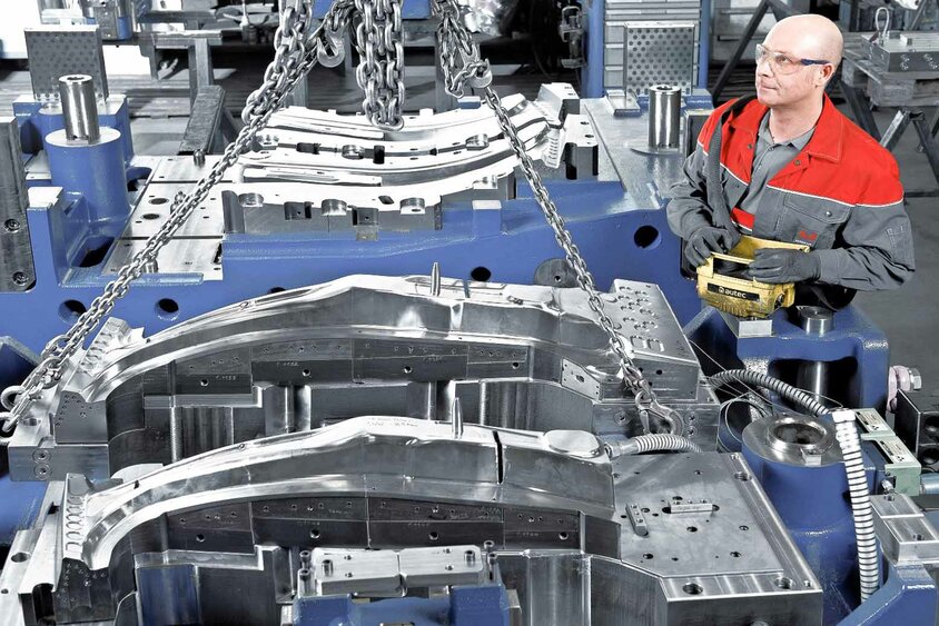 A tool manufacturing technician operates a crane system to assemble active components of a hot forming tool at weba Werkzeugbau, leader for toolmaking solutions in sophisticated quenching process. 