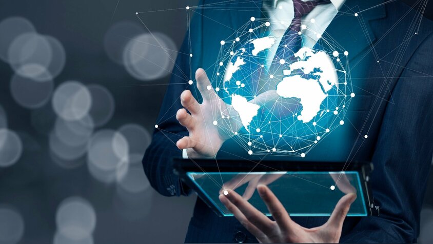 3DEXPERIENCE onCloud - Standortübergreifender Echtzeit-Datenzugriff Geschäftsmann berührt den Bildschirm eines Tablet-PCs, auf dem ein blauer Internet-Globus zu sehen ist. Das Bild symbolisiert den Upgrade von weba Werkzeugbau auf 3DEXPERIENCE onCloud.