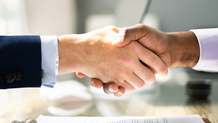 Prozesstechnik Presshärten Partnerschaft Handschlag von zwei Geschäftsleuten über einen Vertrag, dass die Partnerschaft von weba Werkzeugbau und Meprotec im Bereich der Prozesstechnik für das Presshärten symbolisiert
