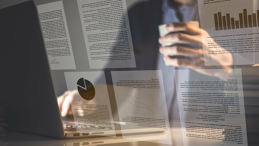 weba Werkzeugbau - Infomaterial über Innovationen in der Warmumformung und Werkzeugbau Ein Geschäftsmann sitzt vor einem offenen Laptop, während das Bild von digitalen Dokumenten überlagert wird, die Grafiken und Texte zeigen.