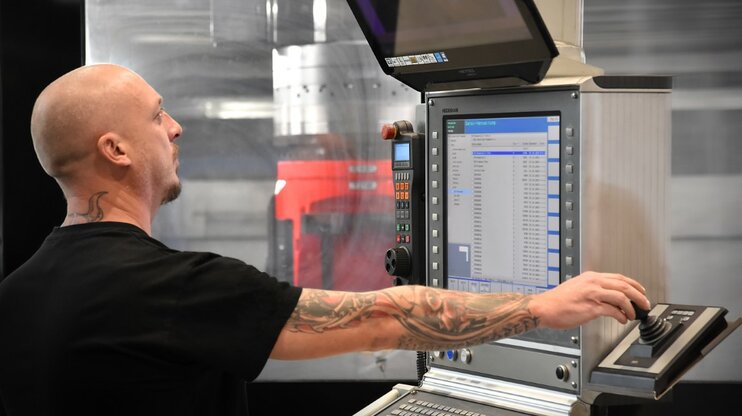 Experienced machining technician operating a modern 5-axis machining center with Heidenhain control at weba in Dietach near Steyr