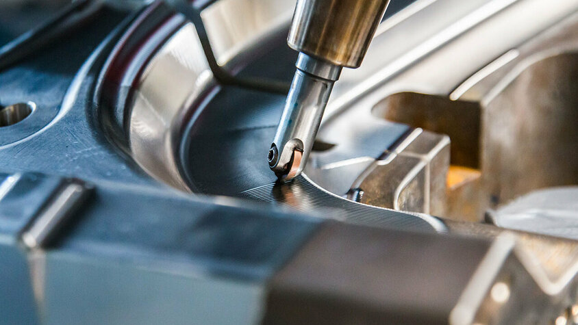 CNC Zerspanung - Metallbearbeitung Detailaufnahme einer CNC Zerspanung; Fräskopf bearbeitet komplexe Form aus Stahl