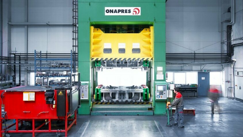 Hydraulische Umformpresse im Werkzeug-Tryout Hydraulische Umformpresse mit Kammerofen, Werkzeugbautechniker am Bedienpult, Tageslicht durch die Fenster. Einsatz der Umformpresse bei einem Werkzeug-Tryout.