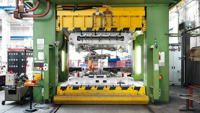 weba Werkzeugbau - Vorreiter in der Warmumformung Warmumformpresse mit eingespanntem Warmumformwerkzeug in der Produktion der weba Olomouc, umgeben von industrieller Ausstattung und Maschinen.