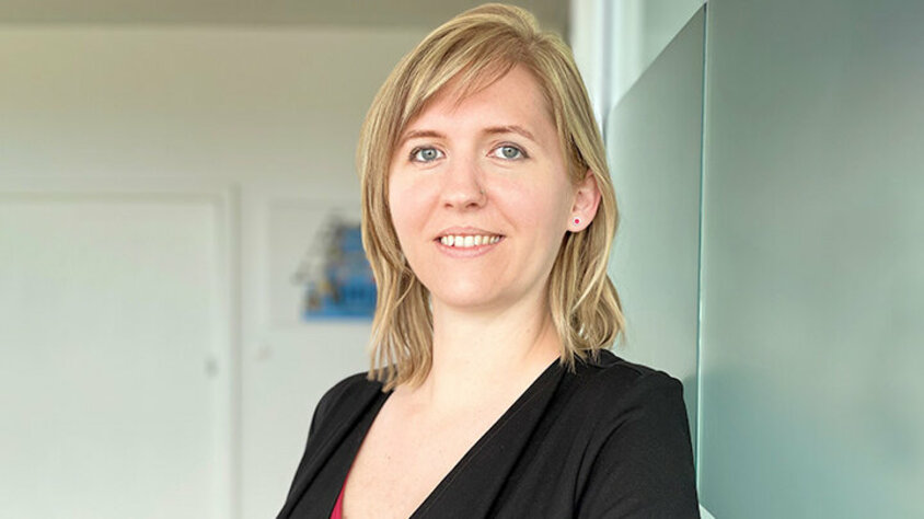 Stellenangebote in Steyr - Ansprechperson Porträt von Tanja Burghuber, Personalmanagerin bei weba Werkzeugbau, entspannt an einer Milchglaswand in Dietach lehnend, mit einem professionellen und freundlichen Ausdruck, betont durch die weiche Beleuchtung und den verschwommenen Hintergrund. Das Foto wird im Kontaktbereich der Stellenangebote in Steyr von weba Werkzeugbau verwendet.