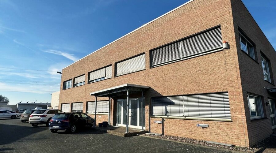 The weba Deutschland GmbH building, a specialist in prototype manufacturing, captured on a sunny day with parking spaces and modern architecture.