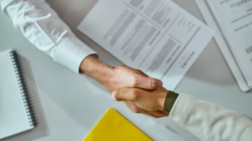 Berufseinstieg in Steyr - Karrierestart bei weba Händeschültteln nach erfolgreicher Vereinbarung über unterzeichneten Verträgen. Das Bild symbolisiert die Vertragsunterzeichnung für einen Berufseinstieg in Steyr bei weba Werkzeugbau.