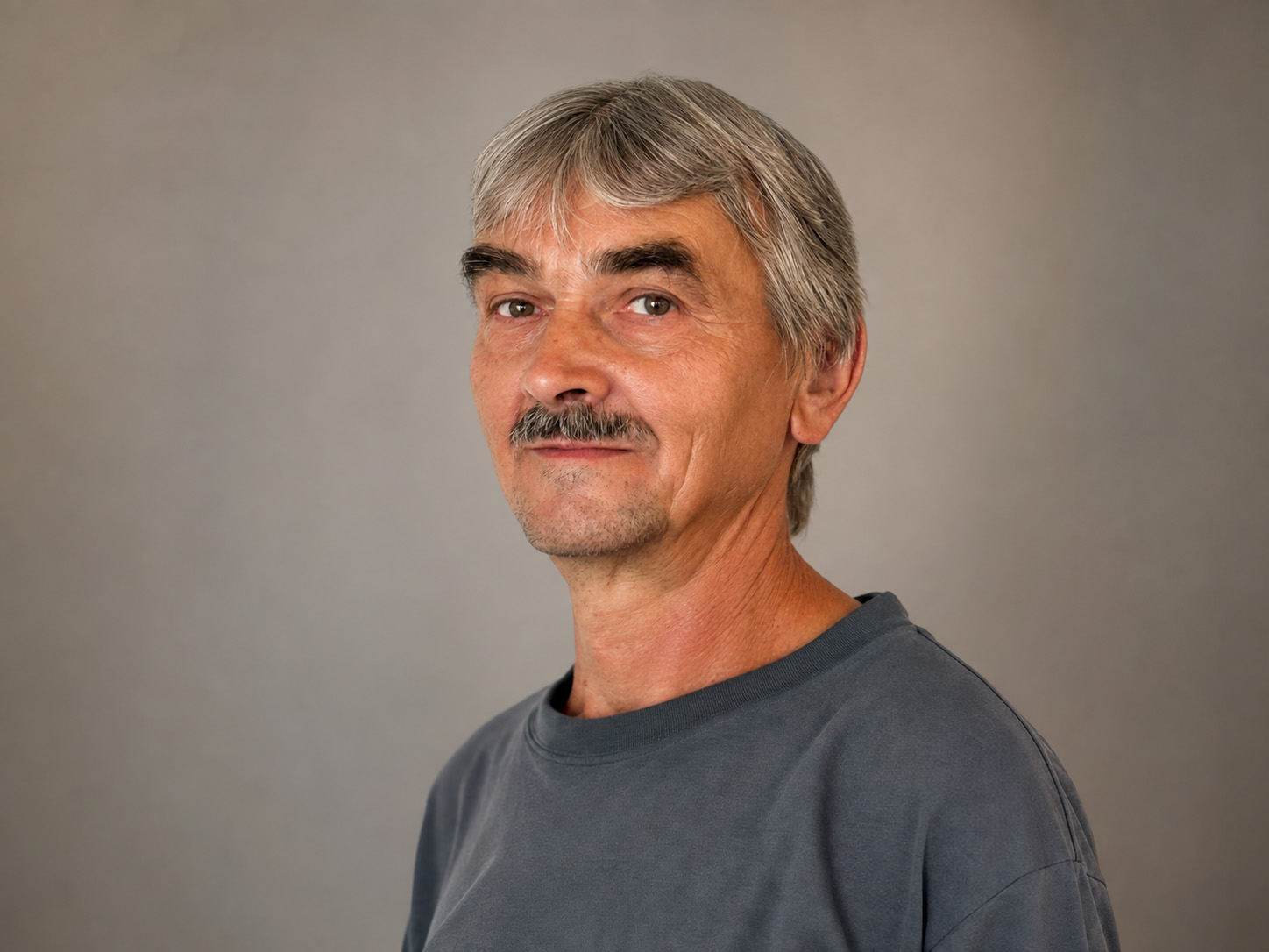 Professional portrait of František Krumpolec against a subtle grey studio background.