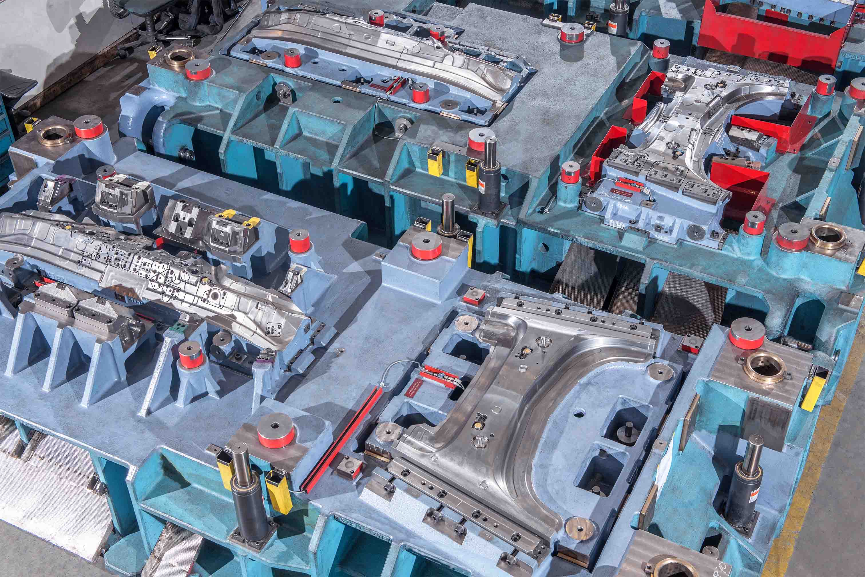 Ausschnitt eines Linienwerkzeugs mit mehreren Umform- und Schneidstationen für die Kaltumformung von Karosserieteilen.